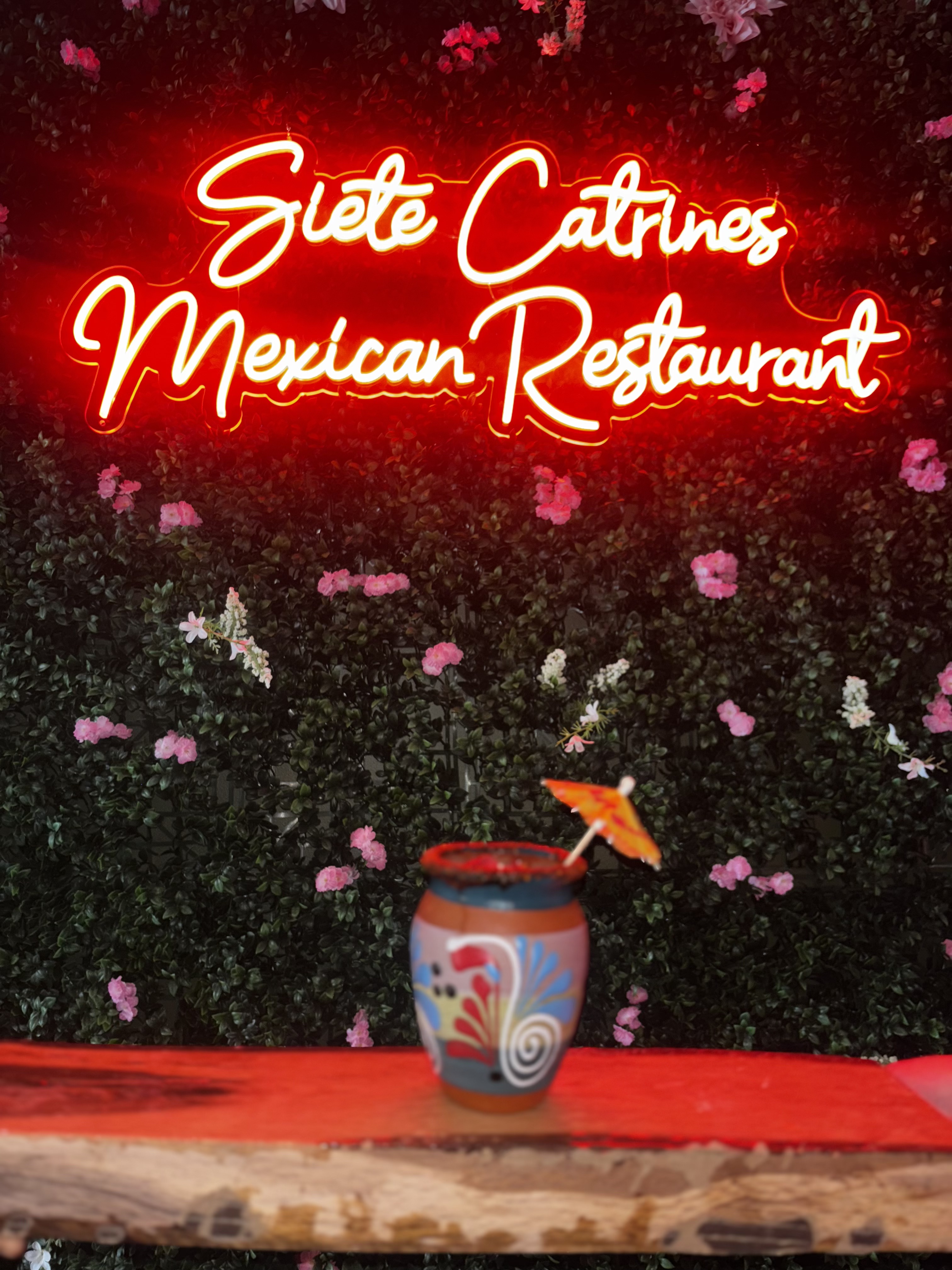 A traditional Mexican cocktail in front of the Siete Catrines neon sign